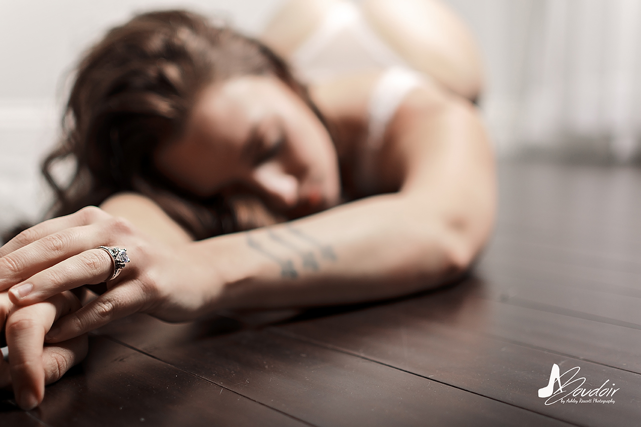 Close up of engagement ring as bride lays on floor