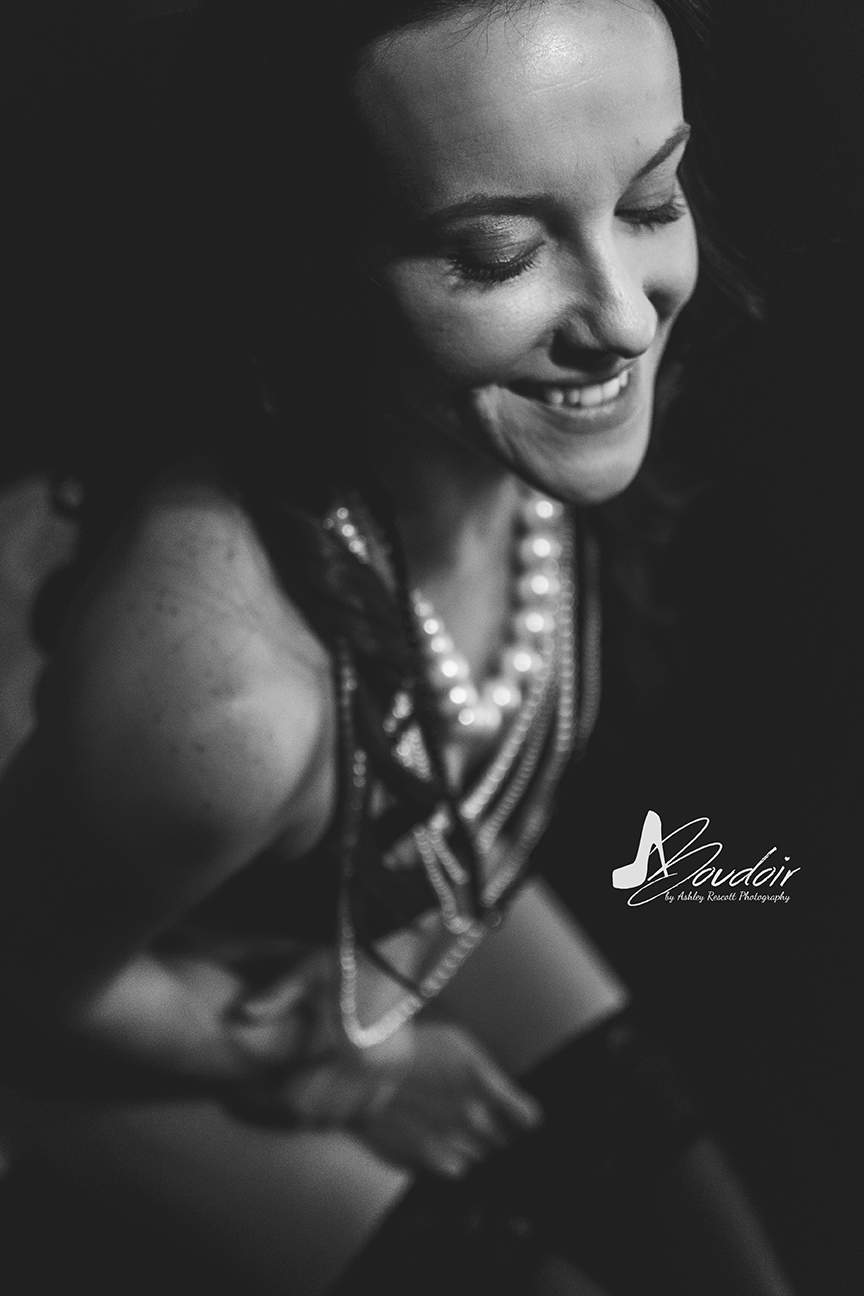 black and white image of sitting woman with pearl necklaces