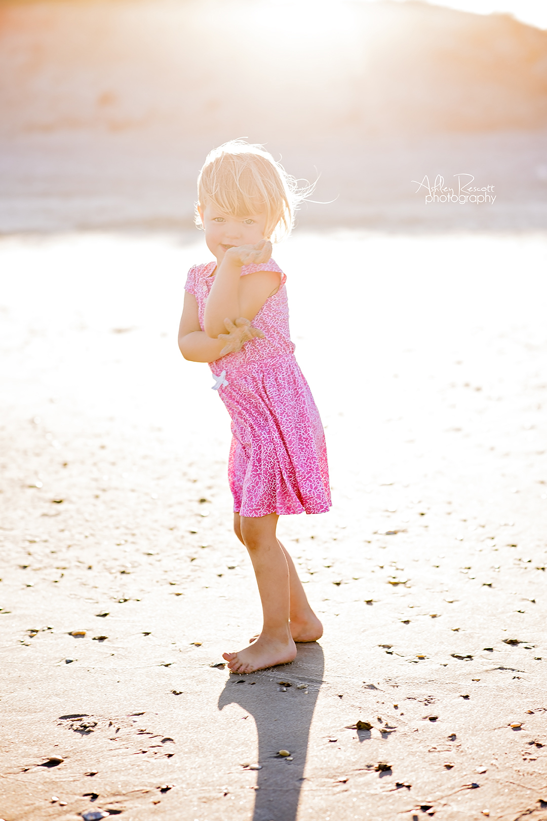 toddler girl on the beach in a pink dress