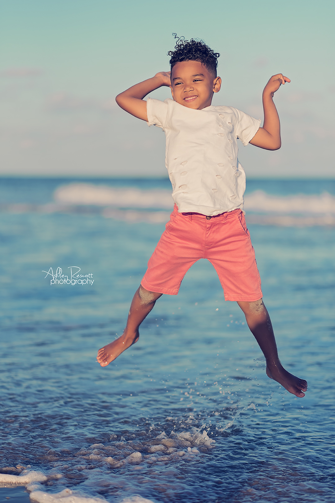 little boy jumping in ocean