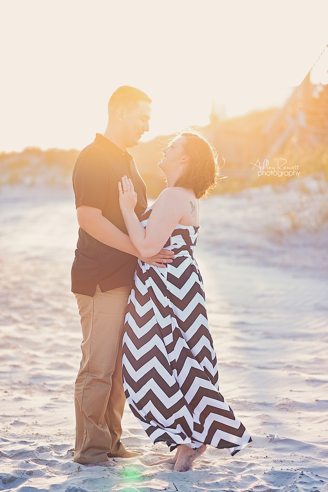 couple in front of sand dunes on beach