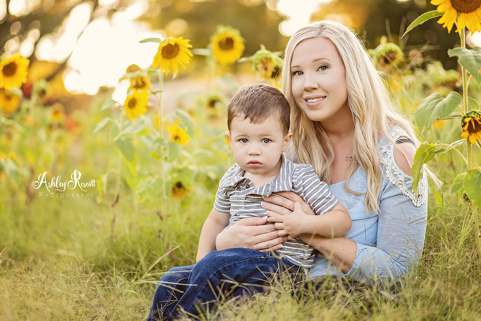 little boy cuddling mom in a sunflower field