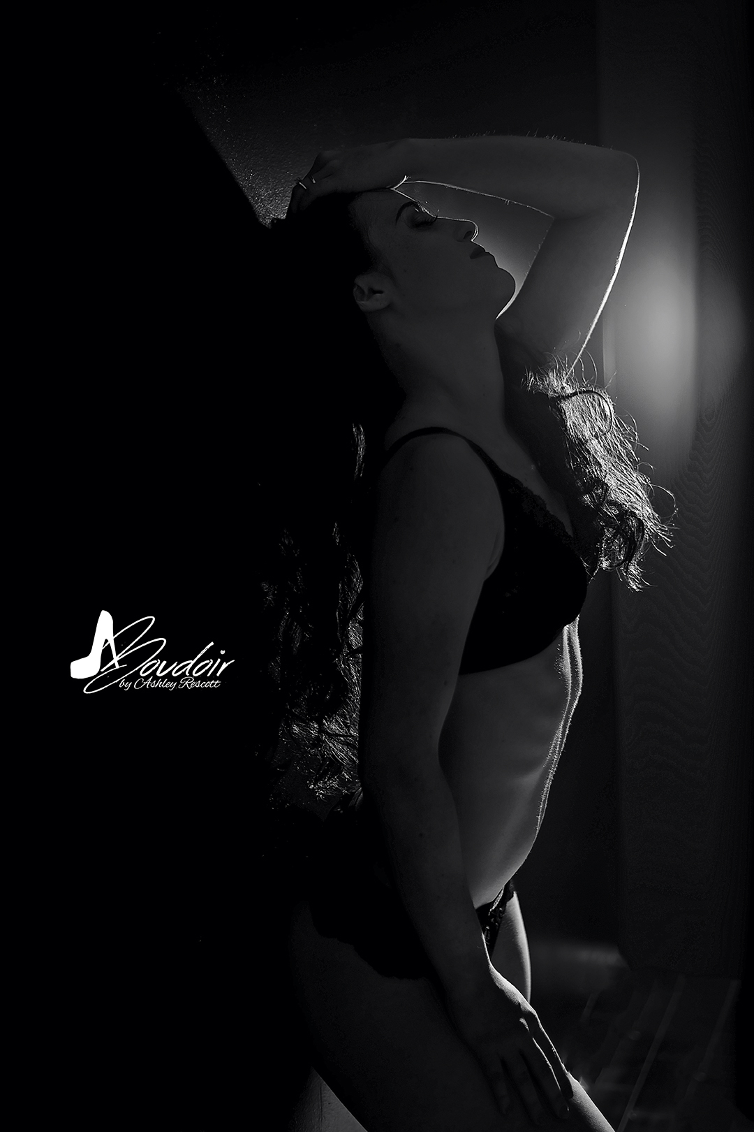 Black & white images of woman leaning against wall, backlit. Standing boudoir image.