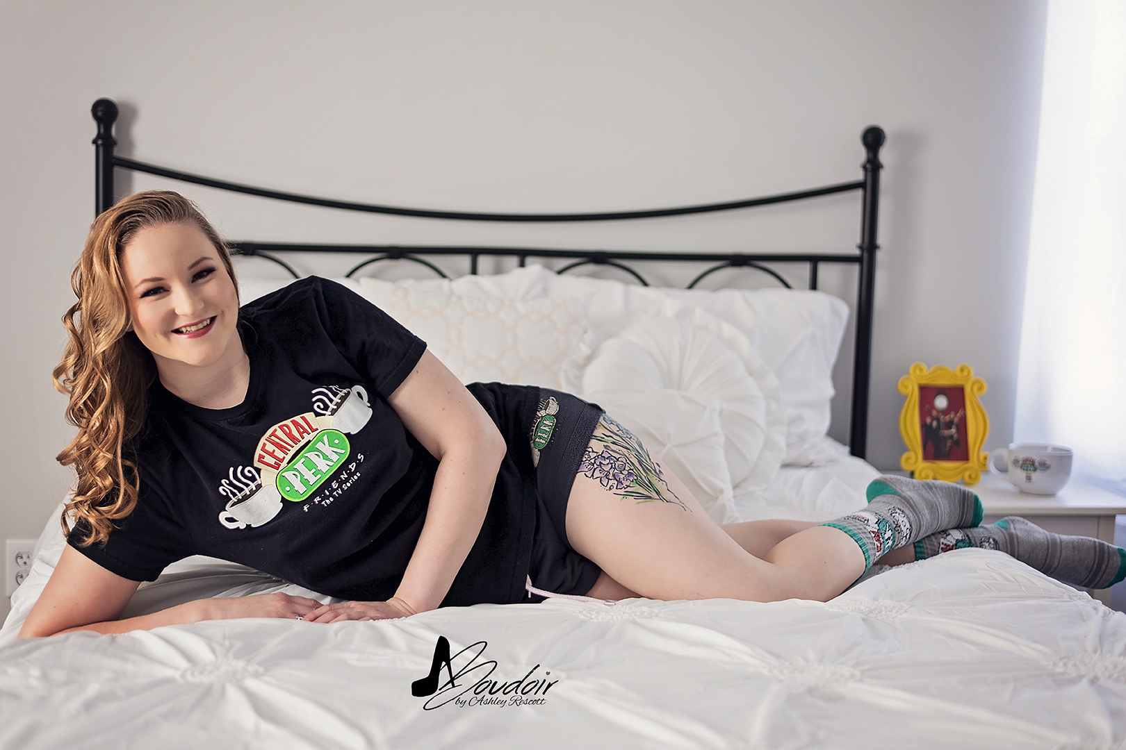 Woman lounging in bed in t shirt and socks