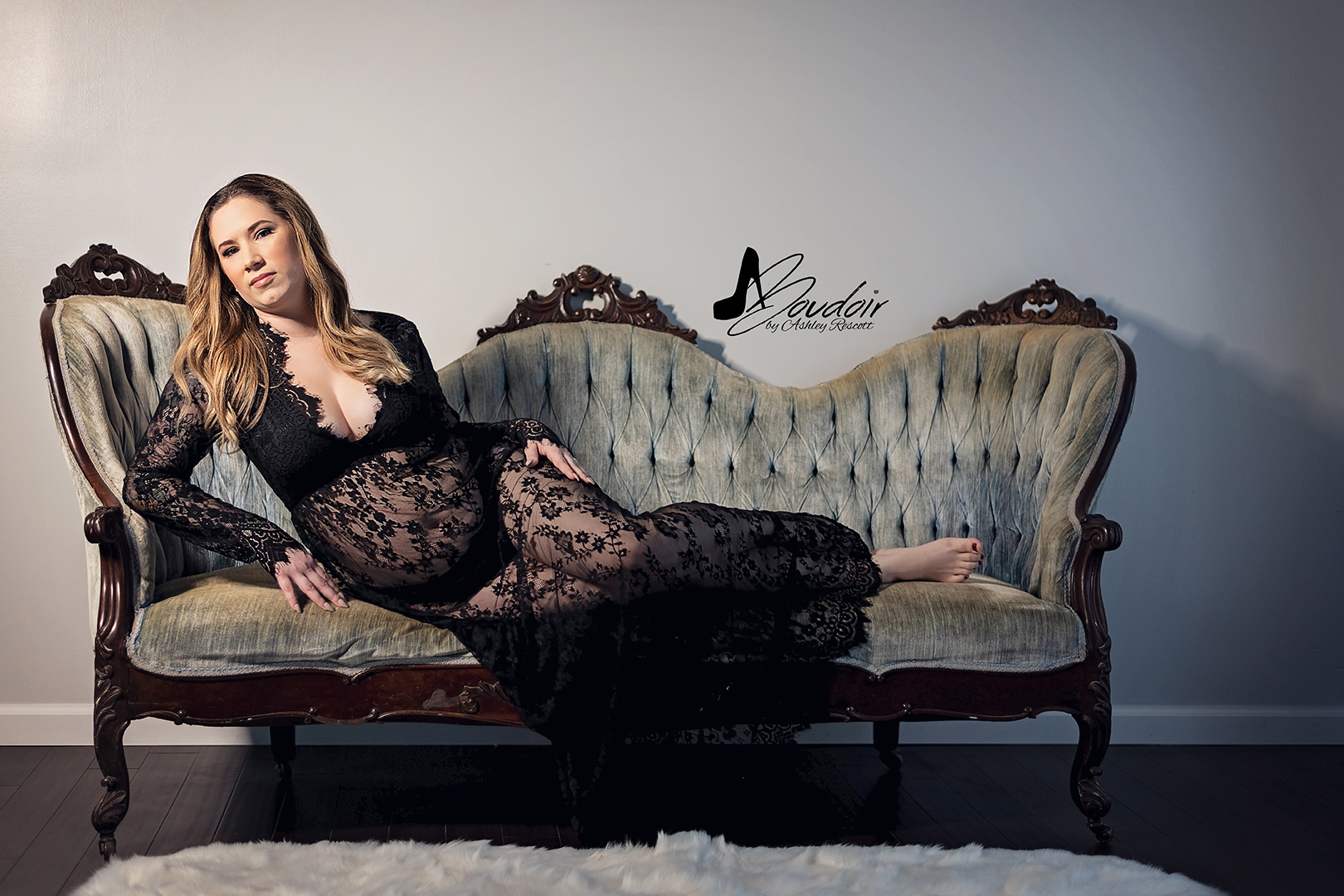 woman in black lace dress lounging on blue victorian couch