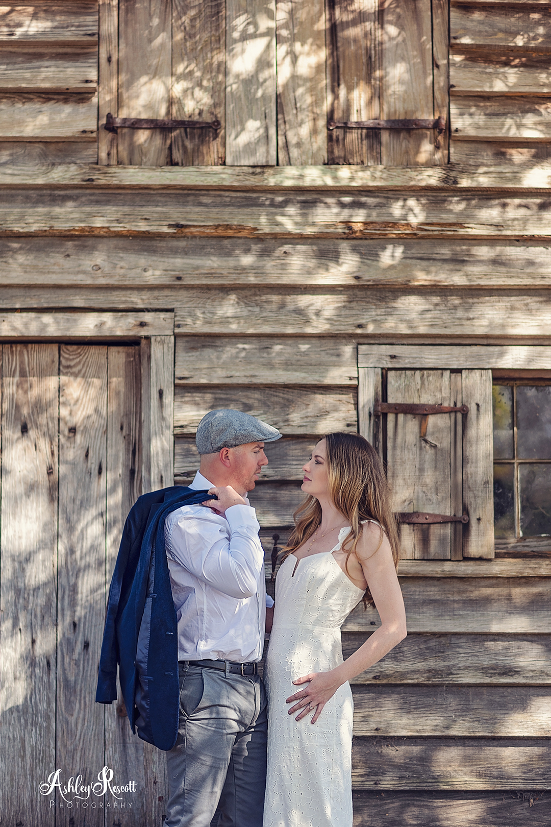 couple in front of wooden building in dappled light