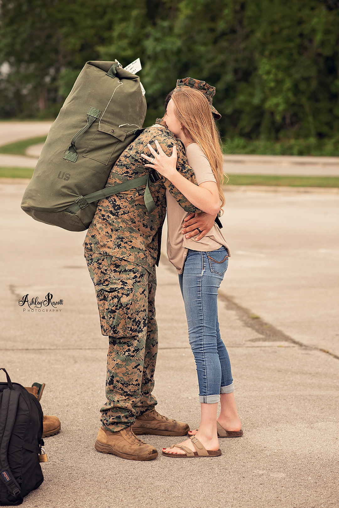 marine hugging his wife with backpack