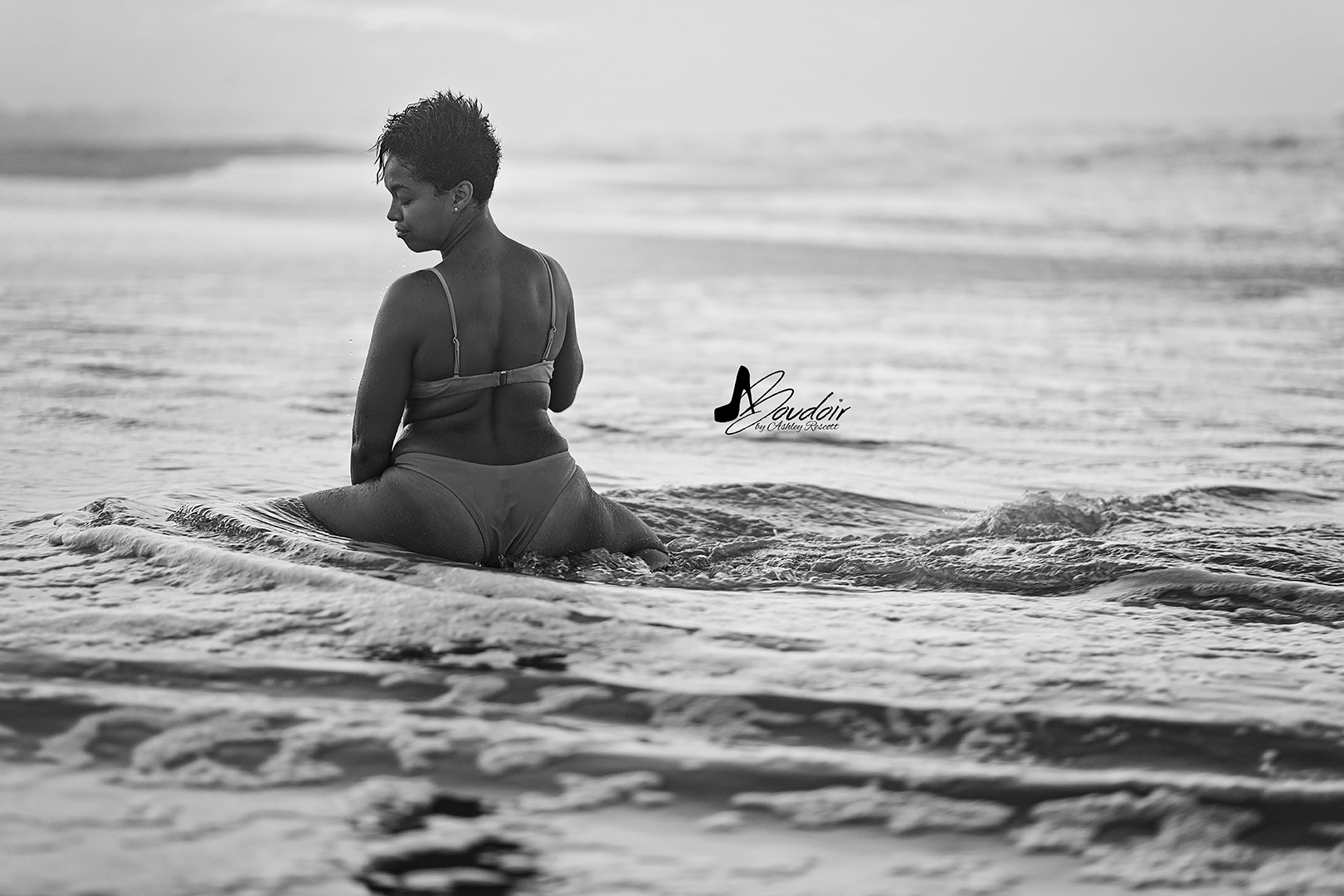black and white portrait of woman sitting in water 