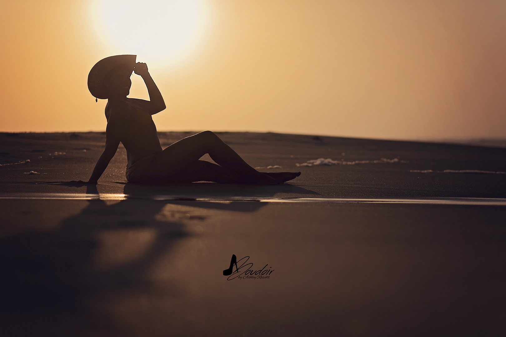 silhouette of woman sitting on beach at sunrise